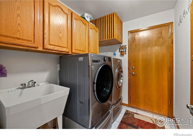 2418 Maplewood Cir E, Longmont, CO 80503 - laundry room with cabinet space, washing machine and clothes dryer, and light tile patterned flooring