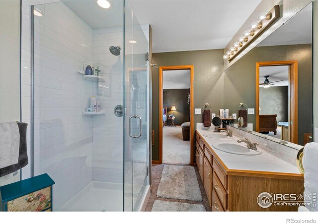 2418 Maplewood Cir E, Longmont, CO 80503 - bathroom with connected bathroom, a stall shower, ceiling fan, and double vanity