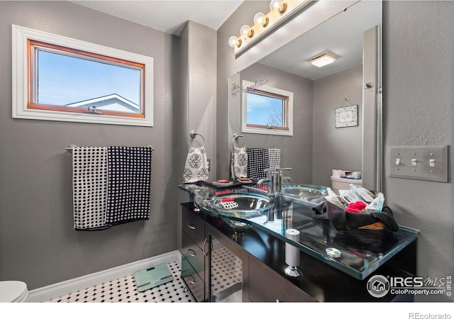 2418 Maplewood Cir E, Longmont, CO 80503 - bathroom with healthy amount of natural light, toilet, vanity, and baseboards