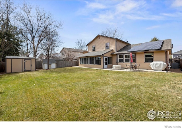 2418 Maplewood Cir E, Longmont, CO 80503 - back of property featuring a storage shed, solar panels, a patio area, an outdoor structure, and cooling unit