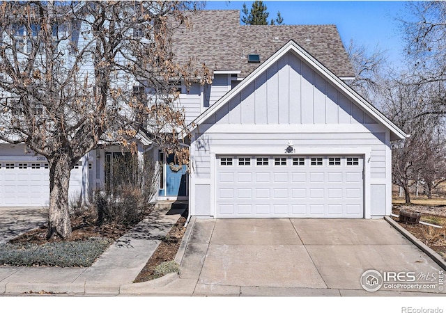 view of front facade featuring board and batten siding, concrete driveway, a garage, and roof with shingles