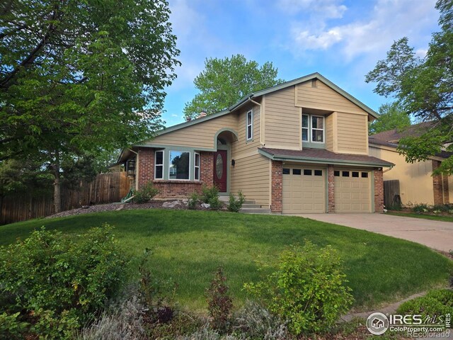 10895 W Half Moon Pass, Littleton, CO 80127 - view of front of house featuring brick siding, concrete driveway, and an attached garage
