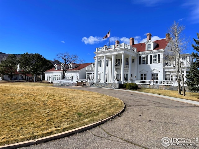 10895 W Half Moon Pass, Littleton, CO 80127 - greek revival house with a balcony, a chimney, and driveway
