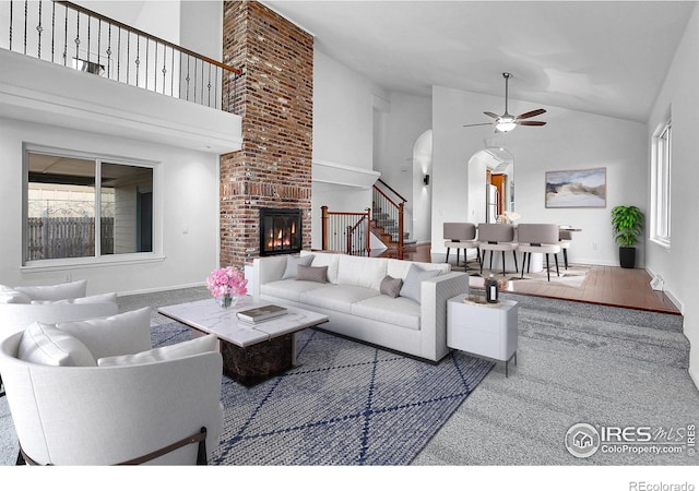 10895 W Half Moon Pass, Littleton, CO 80127 - living area with ceiling fan, stairway, arched walkways, plenty of natural light, and high vaulted ceiling
