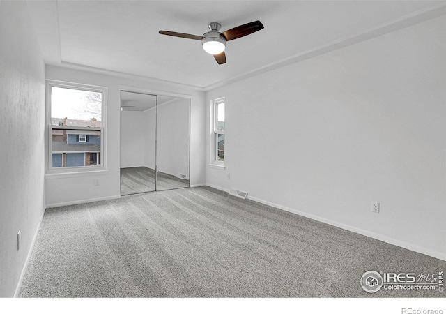 10895 W Half Moon Pass, Littleton, CO 80127 - unfurnished bedroom with multiple windows, carpet floors, a closet, and baseboards
