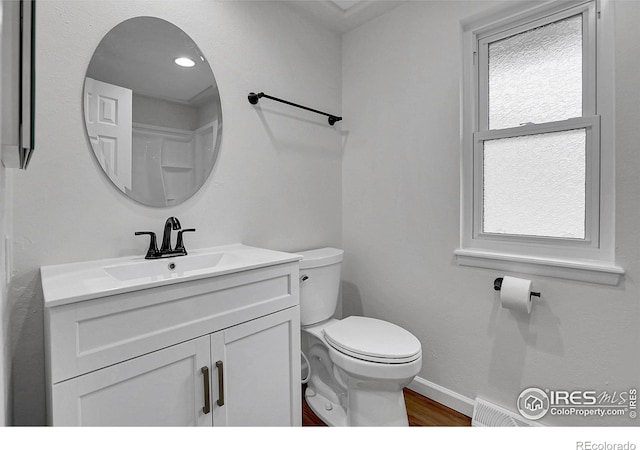 10895 W Half Moon Pass, Littleton, CO 80127 - half bath with vanity, toilet, wood finished floors, baseboards, and healthy amount of natural light