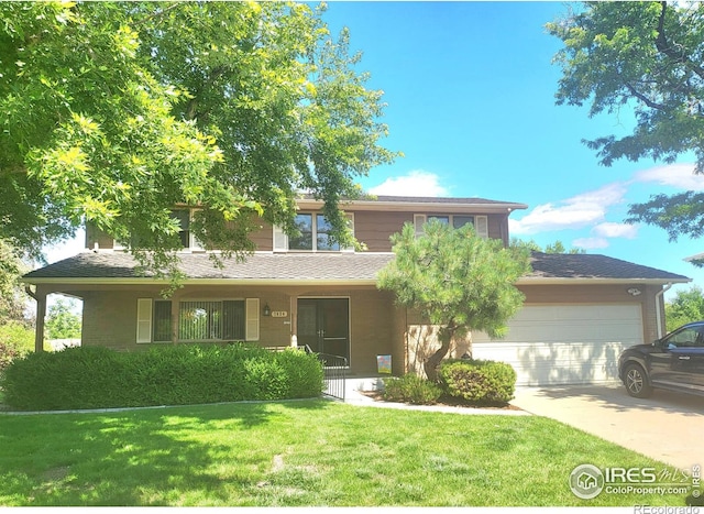 view of front of house with an attached garage, a shingled roof, driveway, and a front lawn