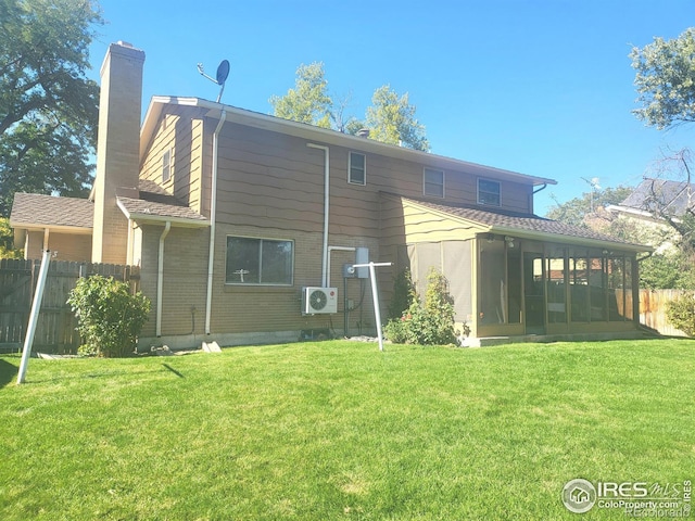 back of house featuring a yard, fence, a chimney, and a sunroom