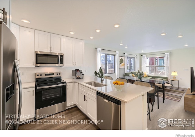 kitchen with appliances with stainless steel finishes, white cabinets, and a healthy amount of sunlight