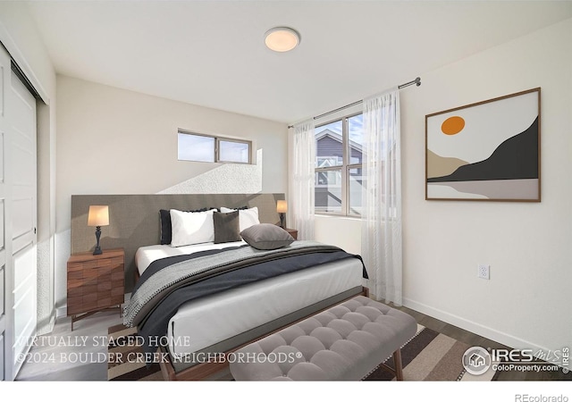 bedroom with a closet, baseboards, and wood finished floors