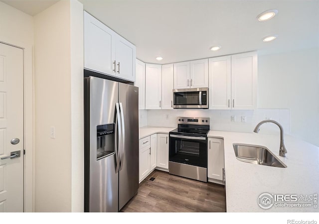 kitchen featuring a sink, tasteful backsplash, white cabinetry, and stainless steel appliances