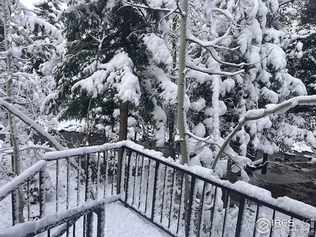 view of snow covered back of property