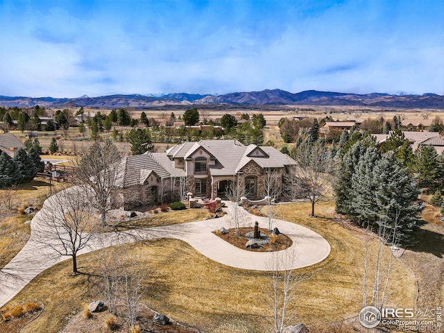 view of front of home featuring a front lawn, a tiled roof, a mountain view, and curved driveway