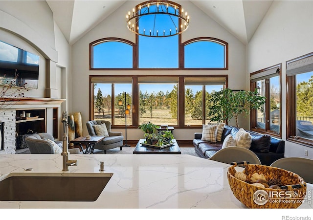 living area featuring lofted ceiling, a notable chandelier, and a fireplace