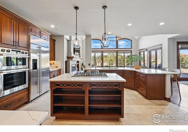 kitchen featuring open shelves, a sink, appliances with stainless steel finishes, a kitchen breakfast bar, and a chandelier