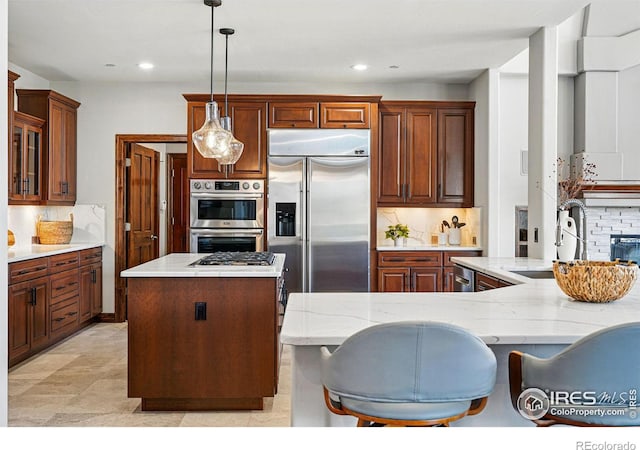 kitchen featuring tasteful backsplash, a kitchen island, recessed lighting, stainless steel appliances, and a sink