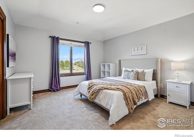 bedroom with light carpet and baseboards