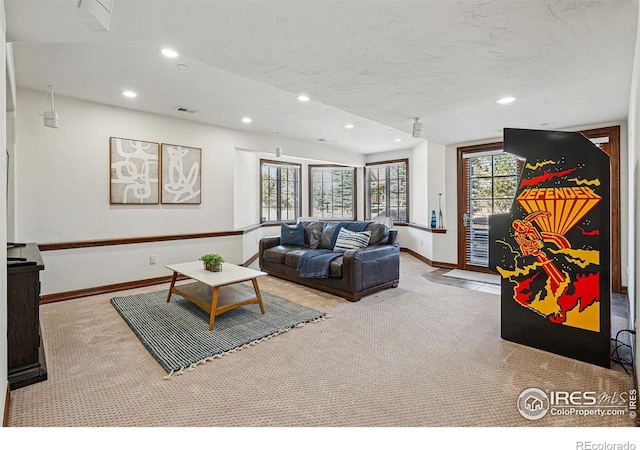 living area featuring visible vents, a textured ceiling, recessed lighting, carpet flooring, and baseboards
