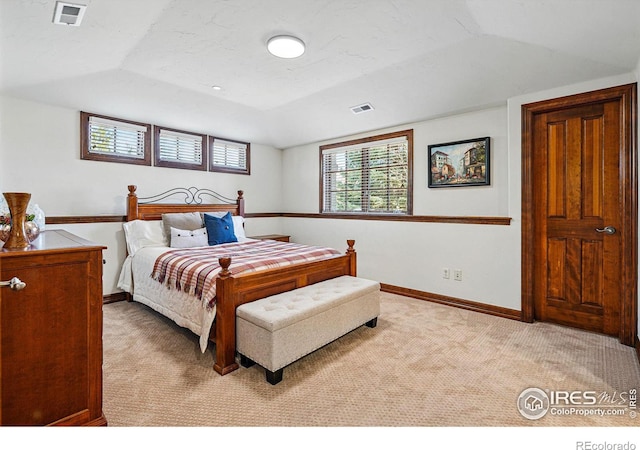 bedroom featuring lofted ceiling, baseboards, visible vents, and light carpet