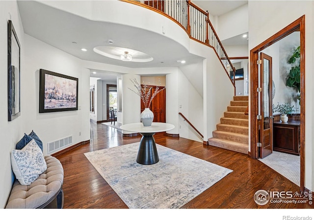 entrance foyer with dark wood-type flooring, stairway, recessed lighting, and visible vents