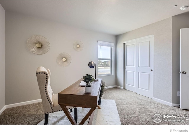 office space with baseboards and light carpet