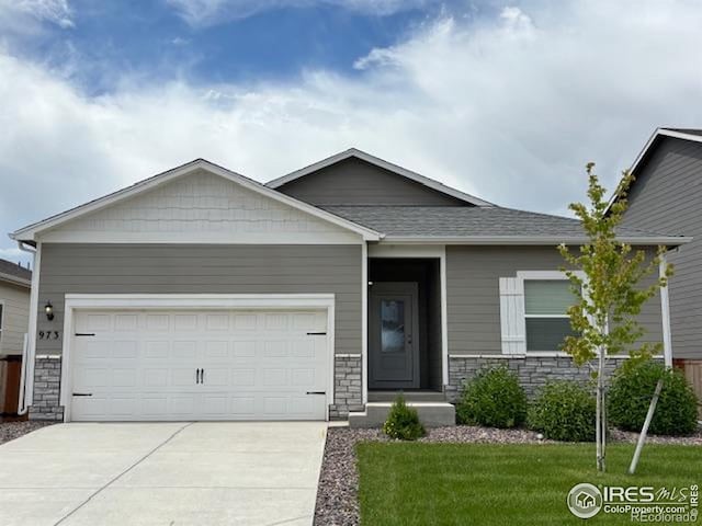 973 Ouzel Falls Rd, Severance, CO 80550 - view of front of property with stone siding, a garage, driveway, a front yard, and a shingled roof