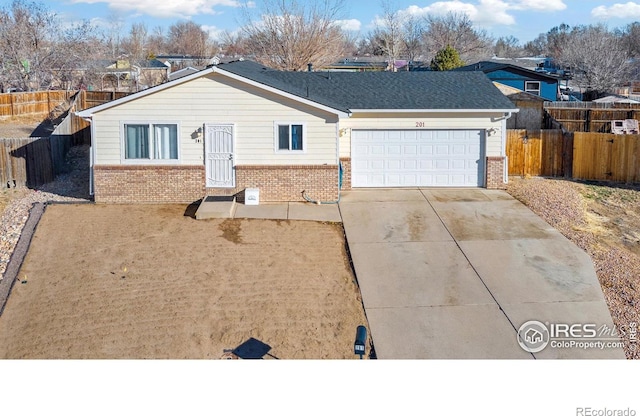 ranch-style home with a garage, brick siding, concrete driveway, and fence