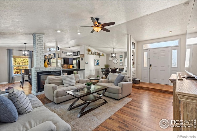 5621 W 27th St, Greeley, CO 80634 - living area featuring lofted ceiling, a textured ceiling, wood finished floors, and ceiling fan with notable chandelier