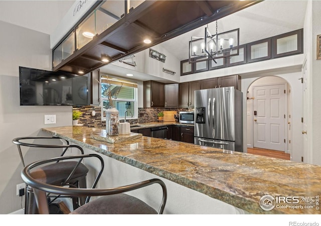 5621 W 27th St, Greeley, CO 80634 - kitchen featuring a sink, dark brown cabinetry, appliances with stainless steel finishes, stone counters, and decorative backsplash