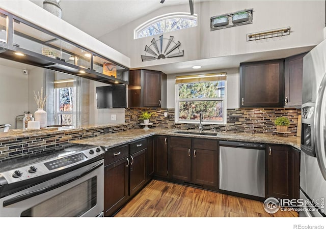 5621 W 27th St, Greeley, CO 80634 - kitchen featuring light stone countertops, a sink, stainless steel appliances, dark brown cabinets, and light wood-type flooring