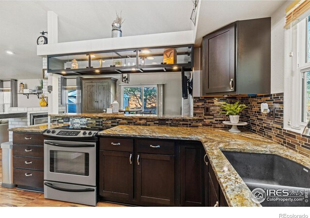 5621 W 27th St, Greeley, CO 80634 - kitchen featuring backsplash, dark brown cabinetry, light stone counters, stainless steel range with electric stovetop, and a sink