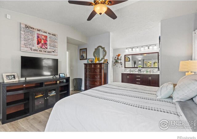 5621 W 27th St, Greeley, CO 80634 - bedroom featuring a textured ceiling, light wood-style flooring, a ceiling fan, and vaulted ceiling