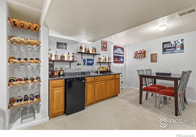 5621 W 27th St, Greeley, CO 80634 - kitchen with a sink, visible vents, dark countertops, and light colored carpet