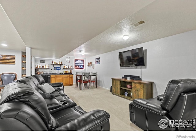 5621 W 27th St, Greeley, CO 80634 - living room with visible vents, baseboards, light colored carpet, wet bar, and a textured ceiling