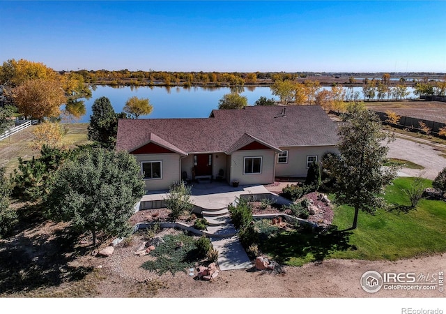 back of house with a yard, a patio, and a water view