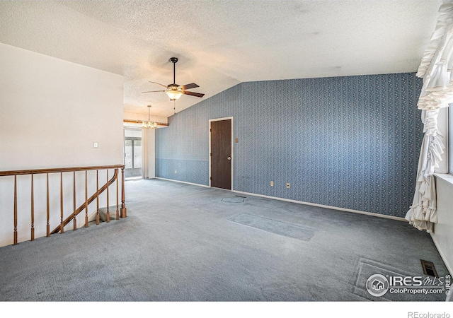 carpeted spare room featuring lofted ceiling, a textured ceiling, ceiling fan, and wallpapered walls