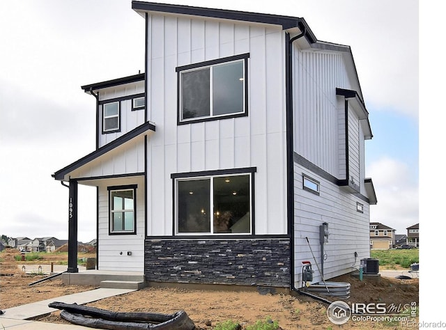 1047 Spartan Ave, Berthoud, CO 80513 - view of front of property with central AC unit, board and batten siding, and stone siding