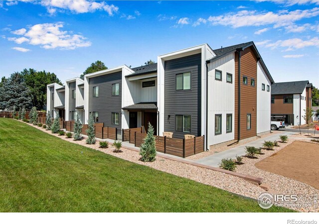 view of front of house featuring a residential view, board and batten siding, and a front yard