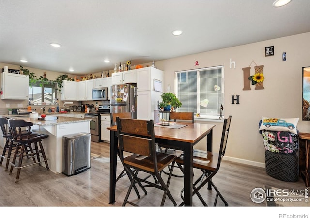 dining room featuring recessed lighting, light wood-type flooring, and baseboards