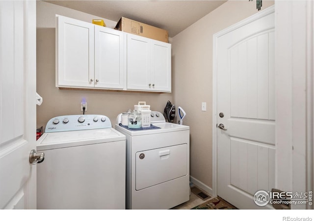 clothes washing area featuring washer and clothes dryer and cabinet space