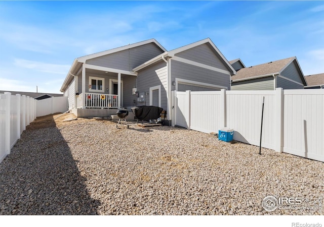 view of property exterior featuring covered porch, a fenced backyard, and an attached garage