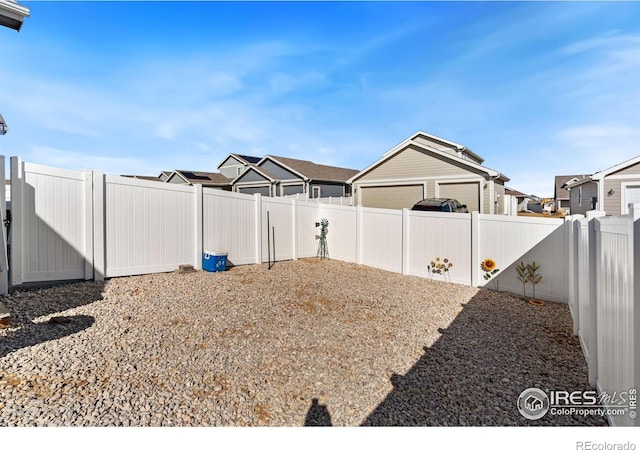 view of yard with a fenced backyard and a residential view