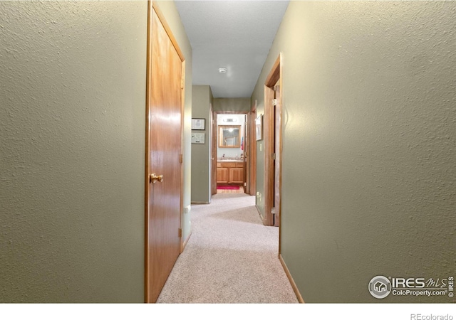 562 E St, Hillrose, CO 80733 - corridor featuring carpet floors, baseboards, and a textured wall