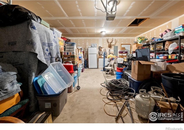 562 E St, Hillrose, CO 80733 - garage with a garage door opener and freestanding refrigerator