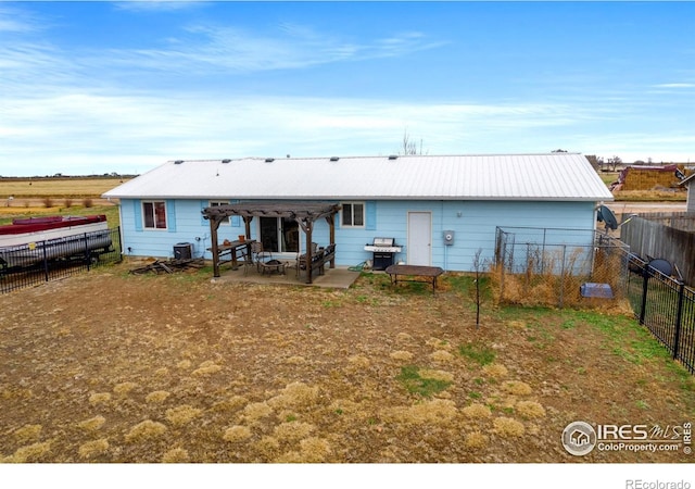 562 E St, Hillrose, CO 80733 - back of house with a pergola, a patio area, metal roof, fence, and central air condition unit
