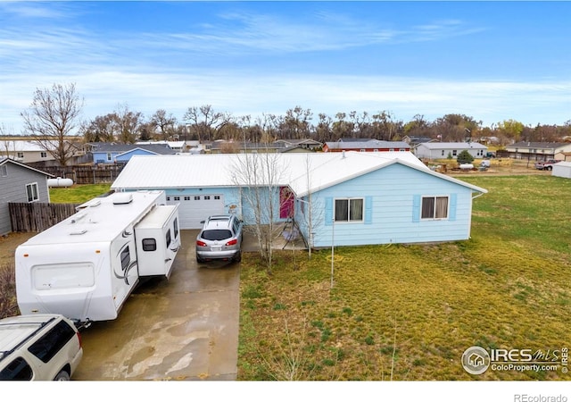 562 E St, Hillrose, CO 80733 - view of front of property with a garage, fence, concrete driveway, and a front lawn