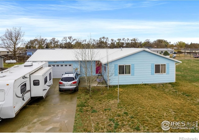562 E St, Hillrose, CO 80733 - view of front of home with concrete driveway, a front yard, and a garage