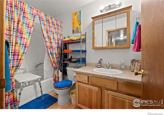 562 E St, Hillrose, CO 80733 - bathroom with shower / bath combination with curtain, wood finished floors, vanity, and toilet