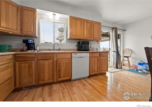 562 E St, Hillrose, CO 80733 - kitchen featuring visible vents, dishwasher, a sink, light countertops, and light wood finished floors