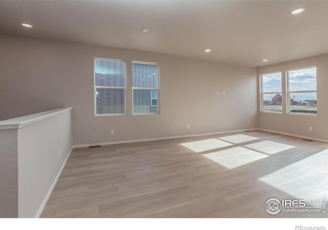 spare room featuring recessed lighting, baseboards, and light wood-style floors